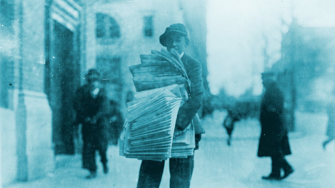 Photo ancienne d'un vendeur de journaux de rue